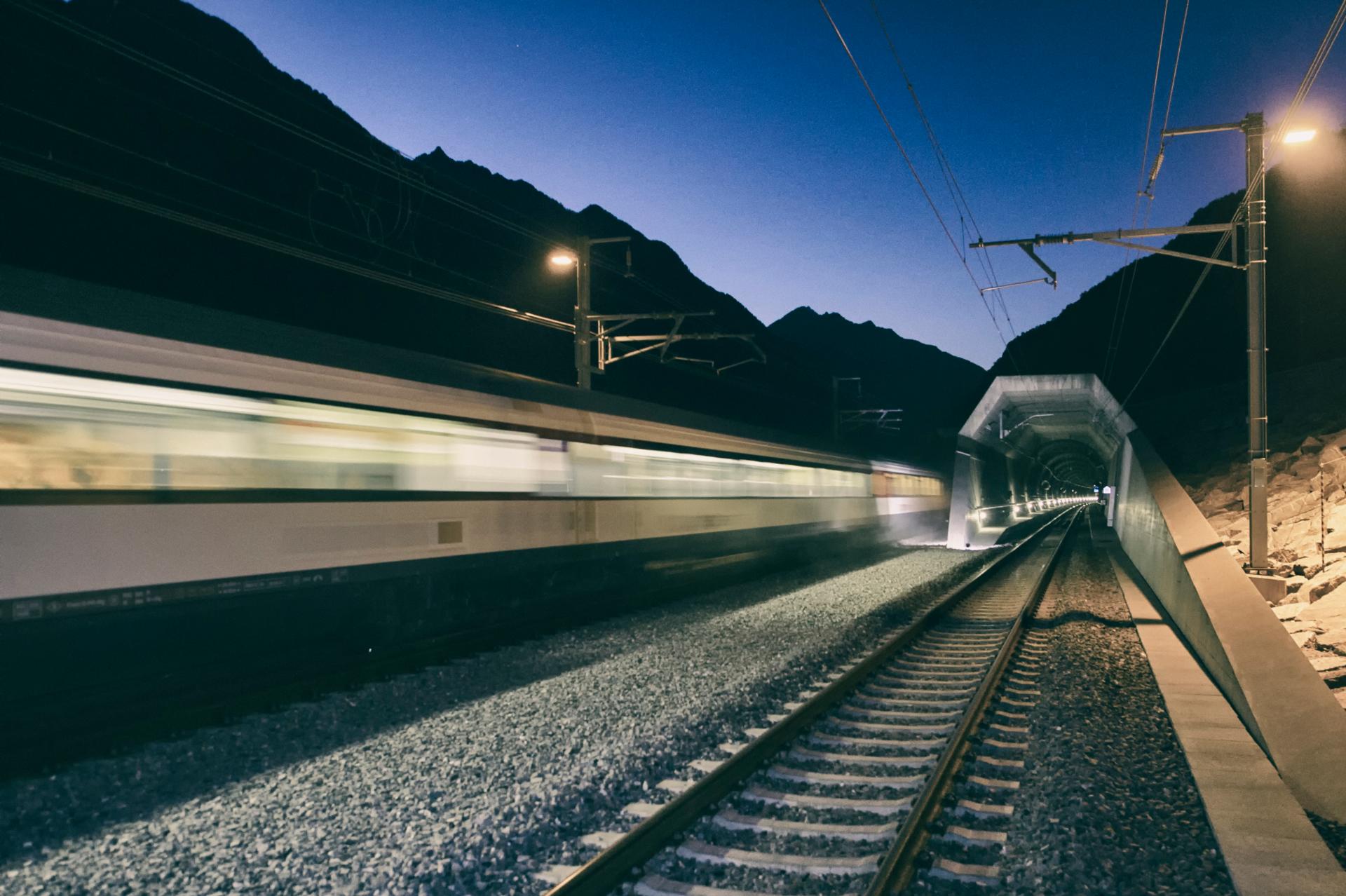 Blurred train travelling on track at dusk