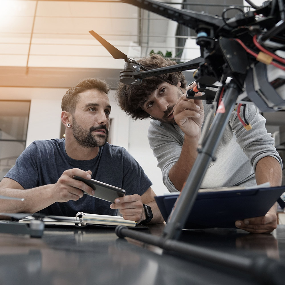 Two male engineers working on a drone