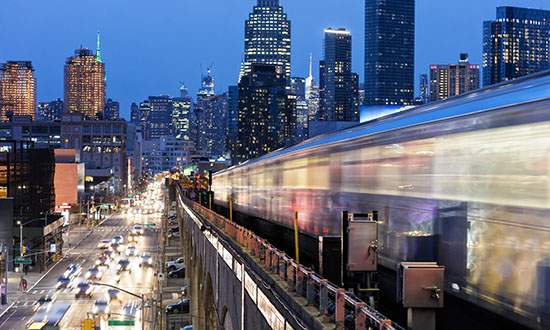 Blurred train travelling on elevated city track